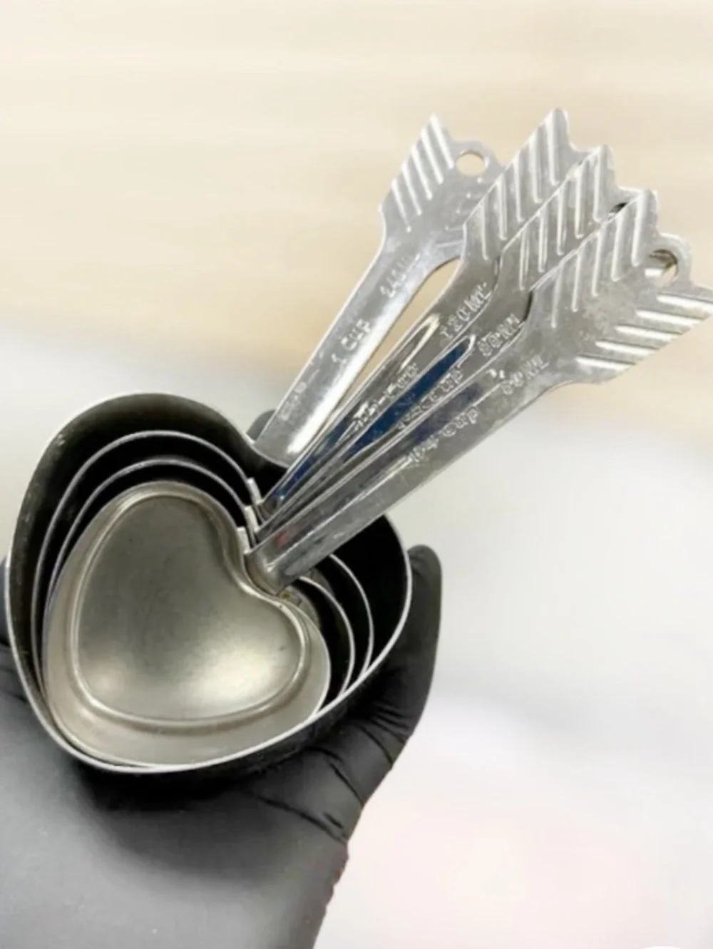 Beehive Handmade stainless steel nesting heart-and-arrow measuring cups.